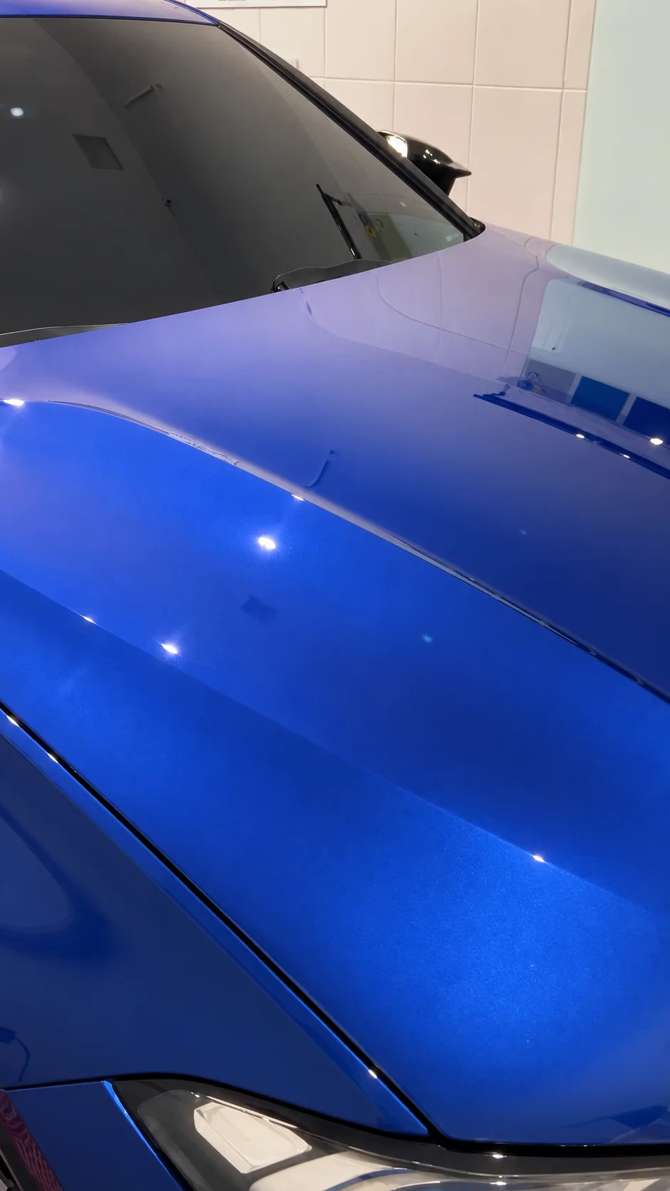 Detalhe do PPF transparente preservando a cor azul e o brilho original do capô de uma BMW